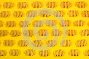 Dry radiatori pasta on a yellow background