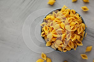 Dry Raw Conchiglie Pasta in a Bowl, top view. Flat lay, overhead, from above. Copy space
