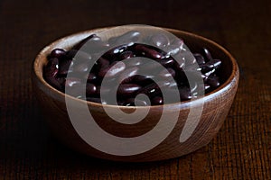Dry red kidney beans in brown wooden bowl.