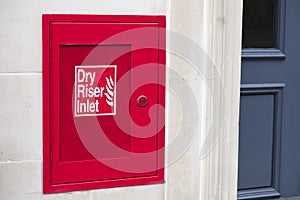 Dry riser red inlet box and sign at wall