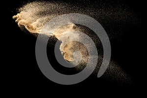 Dry river sand explosion.Brown color sand splash against black background