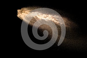 Dry river sand explosion. Brown colored sand splash against  black background