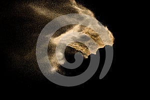 Dry river sand explosion. Golden color sand splash against black background