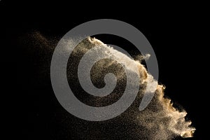 Dry river sand explosion. Golden color sand splash against black background