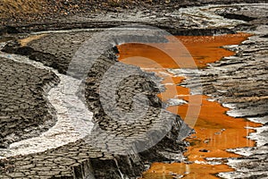 Dry riverbed with cracked mud in hot summer