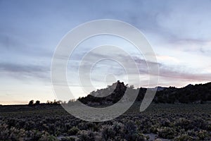 Dry rocky desert mountain landscape with trees. Sunny Sunset Sky.