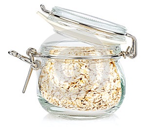 Dry rolled oats in a open transparent glass jar with rubber seal and metal clamp on lid isolated on white background