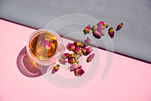 Dry rose buds, a teacup on a pink background. Tea with rose buds.   dried rose buds on a pink surface.