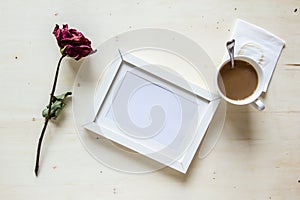 Dry rose and picture frame with coffee