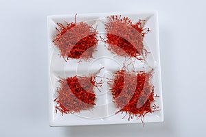 Dry Saffron Spice on a white Plate on white Background photo