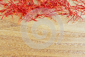 Dry saffron stigmas on a wooden surface. Place for your text. Saffron spice.