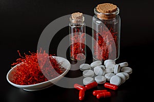 Dry saffron threads and pills on a white background. The use of saffron in medicine photo