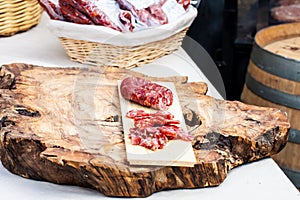 Dry sausage and Italian salami on raw wood cutting board
