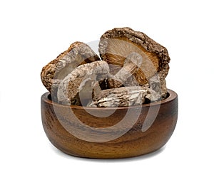 Dry shiitake mushrooms with wooden bowl isolated on white background
