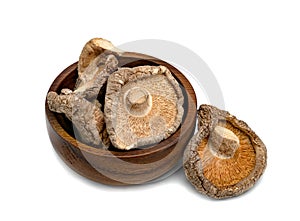 Dry shiitake mushrooms in wooden bowl isolated on white background