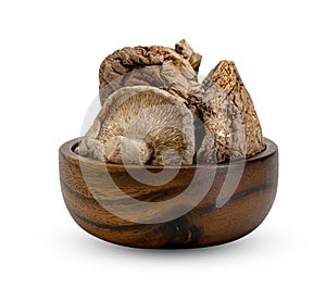 Dry shiitake mushrooms in wooden bowl isolated on white background