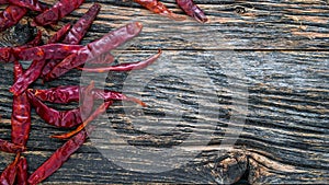 Dry sicy red pepper on rustic wooden background from above with copy space