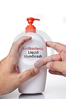 Dry skin on finger with bottle of antibacterial liquid handwash. Frequent hand washing causes skin dryness