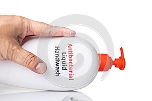 Dry skin on finger with bottle of antibacterial liquid handwash. Frequent hand washing causes skin dryness