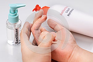 Dry skin on finger with bottle of antibacterial liquid handwash and hand sanitizer. Frequent hand washing causes skin