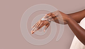 Dry Skin Treatment. Unrecognizable African American Woman Applying Moisturizing Cream On Hands