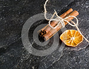 Dry slices of citrus fruits on a black slate background.