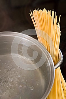 Dry spaghetti with boiling water in a pan