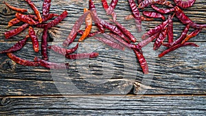 Dry spicy red pepper on rustic wooden background from above with copy space