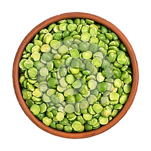 Dry split green peas in a bowl isolated on white background, top view