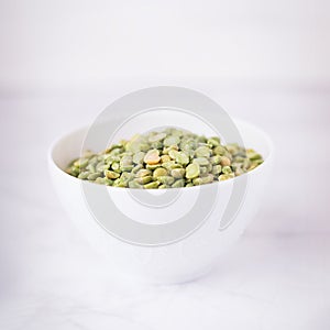 Dry split light green peas in a white cup