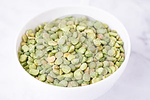 Dry split light green peas in a white cup