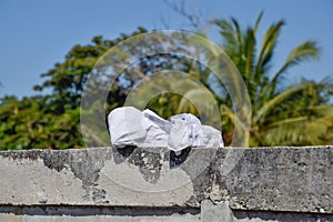 Dry student shoes in the sun on old wal