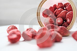 Dry sublimated strawberry scattering out of a jar, confectionery ingredient for desserts and sweets. selective focus