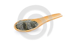 Dry tea with green leaves in wooden spoons on white background