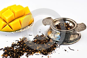 Dry tea herbs with fruit and fresh mango on white background. Selective focus