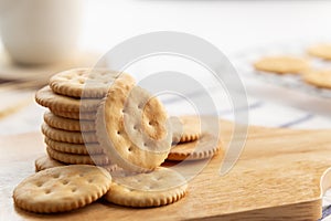 Dry thin circle crispy crackers on cutting board on wood table.