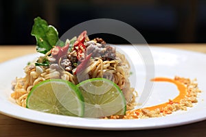 Dry Tomyum noodles in decorated white plate