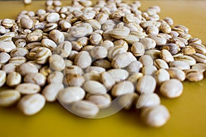 Dry and uncooked brown beans with a warm and yellow background