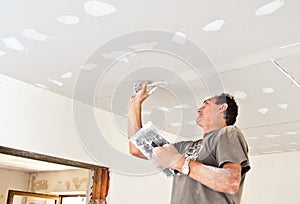 Dry waller working at the ceiling photo