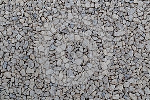 Dry white limestone ballast flat full frame background. Small gray dusty broken macadam stones texture.