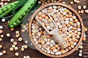 Dry yellow peas in spoon on wooden background, legumes for healthy diet, vegan or vegetarian food concept