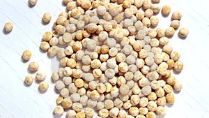 Dry yellow peas on a white spinning surface.