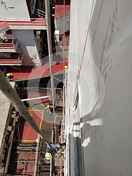 Drydock worker working by hanging