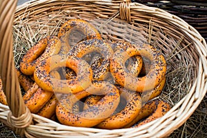 Dryers, bagels, golden baked and sweet round buns with poppies in the form of rings in wicker baskets made from a vine. Appetizing