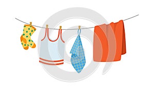 Drying children`s clothes and accessories after washing on a rope.