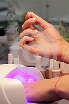 Drying and fixing a transparent base base applied to the nails before using shellac with an ultraviolet lamp