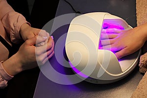 Drying and fixing a transparent base base applied to the nails before using shellac with an ultraviolet lamp