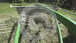 Drying hay by turning with a rotor tractor rake