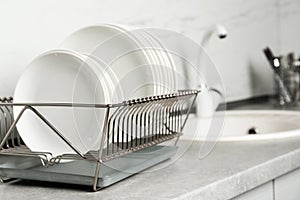 Drying rack with clean dishes on kitchen counter.