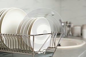 Drying rack with clean dishes on kitchen counter.